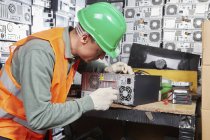 Arbeiter in Computer-Recyclinganlage öffnet PC-Gehäuse — Stockfoto