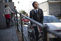 Man pushing bicycle on city street — Stock Photo