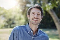 Retrato de homem sorridente caucasiano no parque — Fotografia de Stock