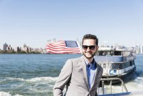 Sonriente hombre de negocios en ferry en East River, Nueva York, EE.UU. — Stock Photo