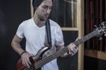 Portrait of bass guitarist at recording studio — Stock Photo