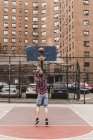 Young man playing basketball on an outdoor court — Stock Photo