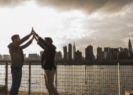 Deux hommes d'affaires donnant cinq à East River, New York, États-Unis — Photo de stock