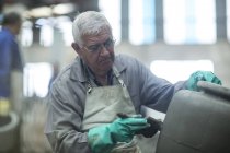 Hombre trabajando en jarra de arcilla en fábrica de macetas industriales - foto de stock