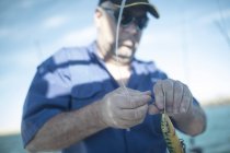 Man applying bait on fishing rod — Stock Photo