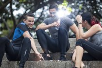 Amici che si prendono una pausa nel parco fitness, seduti sulle scale — Foto stock