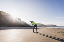 Man doing stretching on beach, france, crozon peninsula — Stock Photo
