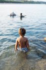 Visão traseira do menino no mar — Fotografia de Stock