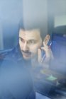 Jeune homme d'affaires au bureau regardant par la fenêtre — Photo de stock