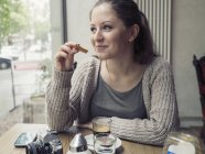 Lächelnde junge Frau mit Kamera in einem Café — Stockfoto