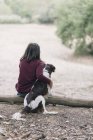 Vue arrière de la jeune femme et de son chien — Photo de stock