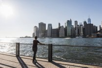 USA, Brooklyn, woman looking at Manhattan skyline — Stock Photo