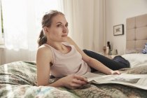 Жінка читання газет в спальні — стокове фото