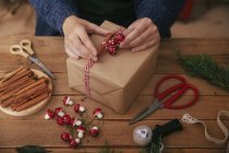 Manos de mujer decorando regalo de Navidad - foto de stock