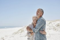 Взрослая пара обнимается на пляже — стоковое фото