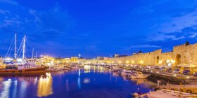 Grecia, Rodi, porto, mura della città e barche da pesca al tramonto — Foto stock
