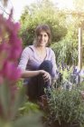Кавказький усміхається жінка садівництва в клумбі — стокове фото