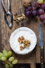 Tavola di legno con camembert, noci e uva — Foto stock