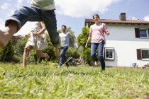 Caucasien insouciant famille courir dans jardin — Photo de stock