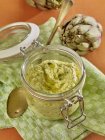 Close up of Artichoke pesto in preserving jar on cloth — Stock Photo
