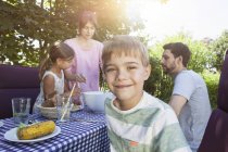 Усміхаючись хлопчик на сім'ї барбекю в саду — стокове фото