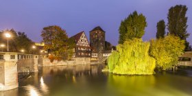 Alemania, Baviera, Núremberg, Casco Antiguo, Puente Max, Weinstadel, Torre de agua y río Pegnitz por la noche - foto de stock