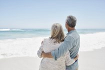 Mature Couple embracing at the beach — Stock Photo