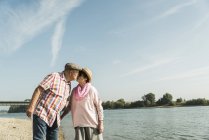 Seniorpaar am Flussufer geküsst — Stockfoto