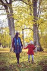 Madre e figlia a piedi nel parco autunnale — Foto stock