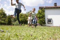 Kaukasische sorglose Familie läuft im Garten — Stockfoto