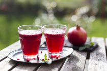 Zumo de granada con semillas en vasos - foto de stock
