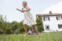 Verspieltes kaukasisches Mädchen mit Eltern im Garten — Stockfoto