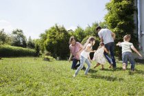 Playful caucasian family of five in garden — Stock Photo