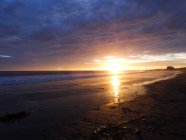 Fernsicht auf Sandstrand und bewölkten Himmel bei Sonnenuntergang — Stockfoto