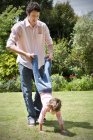 Uomo che gioca con la sua figlioletta in giardino — Foto stock