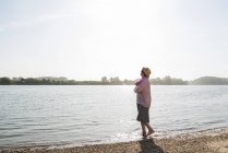 Mujer mayor relajándose a orillas del río - foto de stock