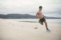 Испания, Ферроль, молодой человек быстро бежит по пляжу — стоковое фото