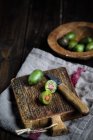 Sliced and whole mini kiwi on wooden chopping board — Stock Photo