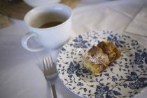 Torta italiana su piatto e tazza di caffè su tovaglia bianca — Foto stock