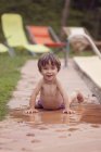 Portrait of smiling little boy besides a swimming pool — Stock Photo