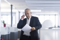 Бізнесмен у відкритому офісі читання документа — стокове фото
