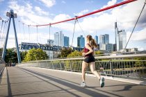 Allemagne, Francfort, jeune femme jogging sur le pont — Photo de stock