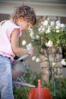Kleines Mädchen mit Gießkanne im Garten — Stockfoto