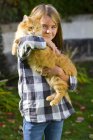 Портрет девушки, держащей на руках табби-кота — стоковое фото
