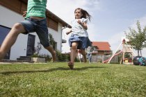 Famiglia caucasica spensierata che corre in giardino — Foto stock
