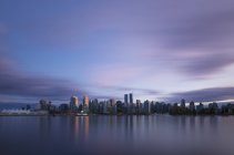 Canada, Vancouver, view to skyline at dusk seen from Stanley Park — Stock Photo