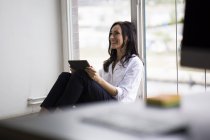 Femme d'affaires travaillant pieds nus sur le sol dans un bureau moderne — Photo de stock