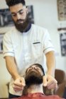 Friseur justiert Bart des männlichen Kunden — Stockfoto