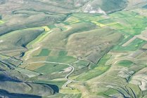 Itália, Úmbria, Parque Nacional Monti Sibillini, Vista aérea dos campos no Piano Grande de Castelluccio di Norcia — Fotografia de Stock