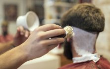 Крупный план парикмахера руки бритья клиента — стоковое фото